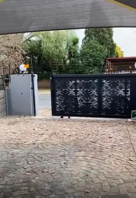 a black iron gate with a stone patio at 26 Rubens apartments in Secunda