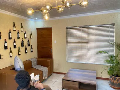a woman is sitting in a waiting room at 26 Rubens apartments in Secunda