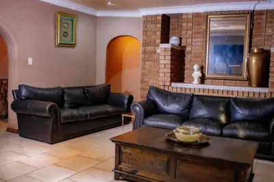 a living room with leather couches and a table at Travel Shift Accommodation in Northam