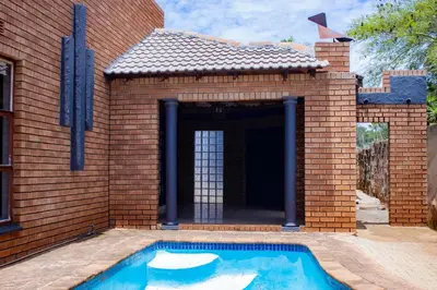 a brick building with a swimming pool in front of it at Travel Shift Accommodation in Northam