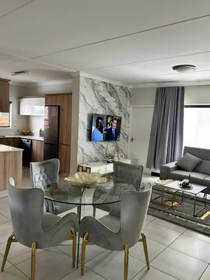 a living room with a glass table and chairs at The Blyde Estate Apartments in Pretoria