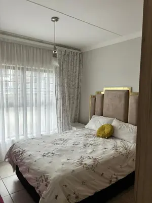 a bedroom with a large bed with a large window at The Blyde Estate Apartments in Pretoria