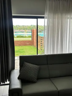 a couch in a living room with a large window at The Blyde Estate Apartments in Pretoria