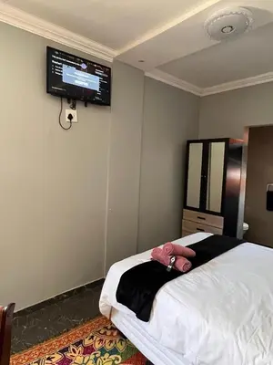 a bedroom with a bed with a tv on the wall at MorningMist Boutique 27 Room 1 in Centurion