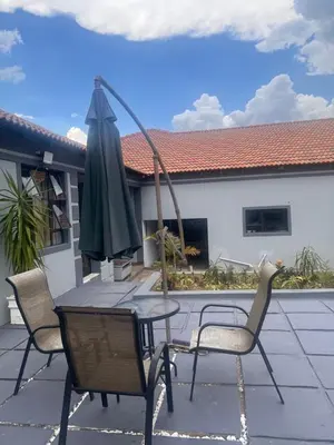 a table and chairs and an umbrella on a patio at MorningMist Boutique 27 Room 1 in Centurion