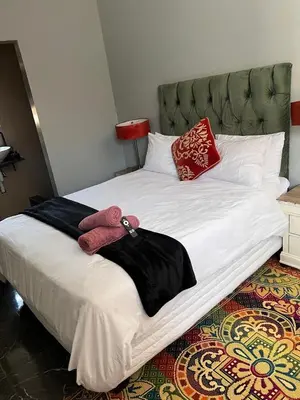 a large white bed with red pillows on it at MorningMist Boutique 27 Room 1 in Centurion