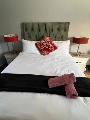 a white bed with two red pillows and two lamps at MorningMist Boutique 27 Room 1 in Centurion