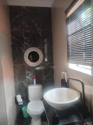 a bathroom with a white toilet and a sink at MorningMist Boutique 27 Room 1 in Centurion