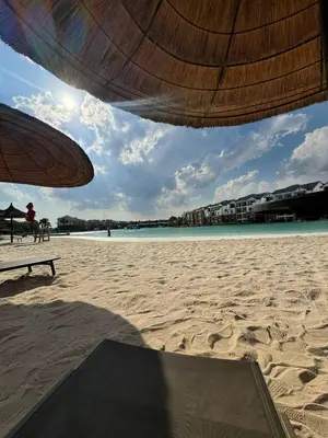 a view of a beach with an umbrella and the ocean at The Dream Escape At The Blyde - 2 Bedroom Apartment in Pretoria