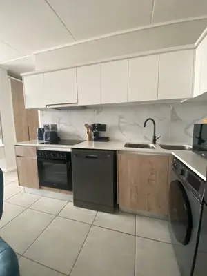 a kitchen with white cabinets and a sink and a dishwasher at The Dream Escape At The Blyde - 2 Bedroom Apartment in Pretoria