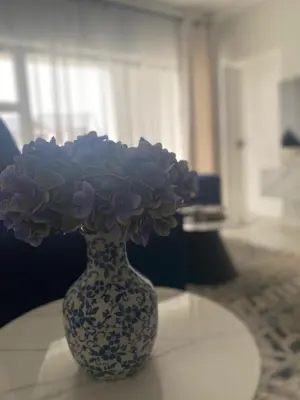 a blue and white vase with purple flowers on a table at The Dream Escape At The Blyde - 2 Bedroom Apartment in Pretoria