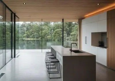 a kitchen with a sink and a counter with stools at De Holiday Home in Haenertsburg