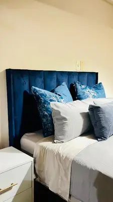 two beds with blue and white pillows on them at Drostdy Hotel in Springs