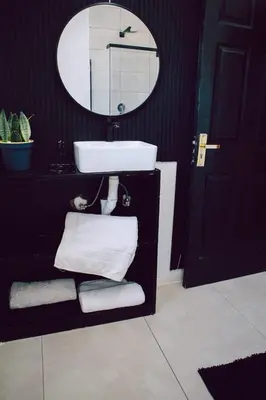 a bathroom with a sink and a mirror and towels at L a Grande deluxe in Benoni