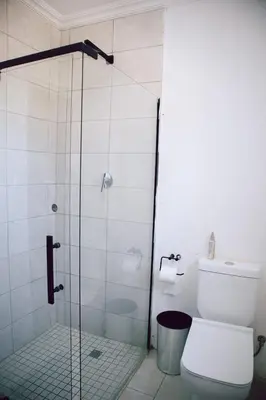a bathroom with a glass shower with a toilet at L a Grande deluxe in Benoni