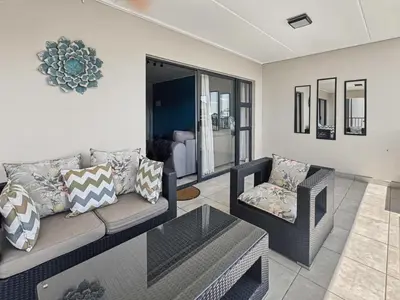 a living room with a couch and a chair at Resort style 1BR-Big balcony-Lagoon Luxury Spa in Midrand