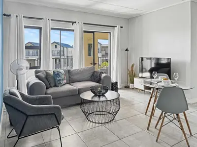a living room with a couch and a table at Resort style 1BR-Big balcony-Lagoon Luxury Spa in Midrand