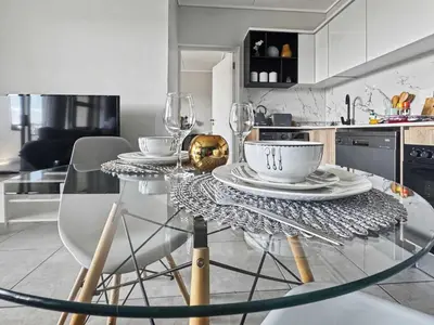 a glass table in a kitchen with wine glasses at Resort style 1BR-Big balcony-Lagoon Luxury Spa in Midrand