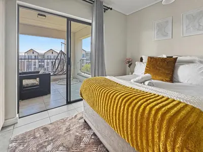 a bedroom with a large bed and a balcony at Resort style 1BR-Big balcony-Lagoon Luxury Spa in Midrand