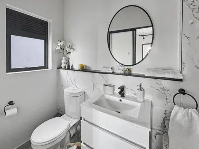 a bathroom with a sink and a toilet and a mirror at Resort style 1BR-Big balcony-Lagoon Luxury Spa in Midrand