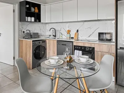 a kitchen with a glass table and chairs in it at Resort style 1BR-Big balcony-Lagoon Luxury Spa in Midrand