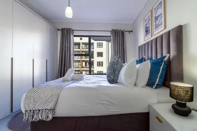 a bedroom with a large white bed with a window at Alimama Spaces Whisken Haven in Midrand