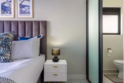 a bedroom with a bed and a lamp on a night stand at Alimama Spaces Whisken Haven in Midrand