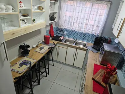 a small kitchen with a table and chairs in it at Luxury Meets Convenience Near City & Travel Links in Pretoria