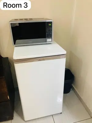 a microwave sitting on top of a white refrigerator at The Bright Guest House in Pretoria
