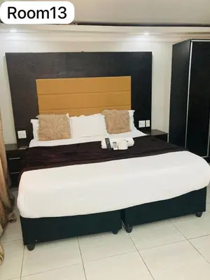 a bedroom with a large bed with a large headboard at The Bright Guest House in Pretoria