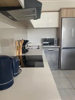 a kitchen with a refrigerator and a counter top at The Dream Escape At The Blyde - 2 Bedroom Apartment in Pretoria
