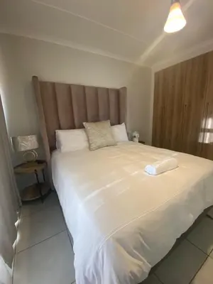 a large white bed with a large headboard in a bedroom at The Dream Escape At The Blyde - 2 Bedroom Apartment in Pretoria