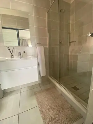 a bathroom with a glass shower and a sink at The Dream Escape At The Blyde - 2 Bedroom Apartment in Pretoria