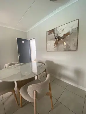 a dining room with a glass table and chairs at The Dream Escape At The Blyde - Lagoon Facing 3 Bedroom Apartment in Pretoria