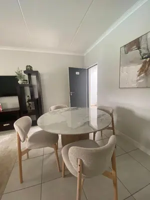 a dining room with a glass table and chairs at The Dream Escape At The Blyde - Lagoon Facing 3 Bedroom Apartment in Pretoria