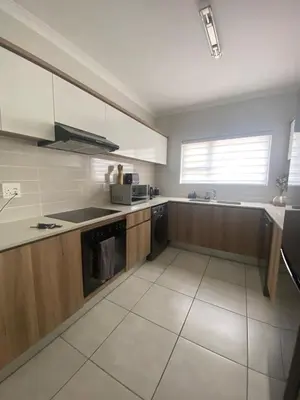 a kitchen with wooden cabinets and a stove top oven at The Dream Escape At The Blyde - Lagoon Facing 3 Bedroom Apartment in Pretoria