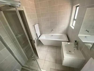 a white bathroom with a tub and a sink at The Dream Escape At The Blyde - Lagoon Facing 3 Bedroom Apartment in Pretoria