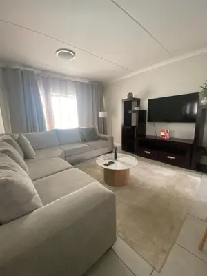 a living room with a couch and a flat screen tv at The Dream Escape At The Blyde - Lagoon Facing 3 Bedroom Apartment in Pretoria