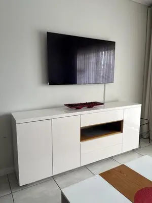 a white entertainment center with a tv on a wall at The Dream Escape At The Blyde - Lagoon Facing 3 Bedroom Apartment in Pretoria