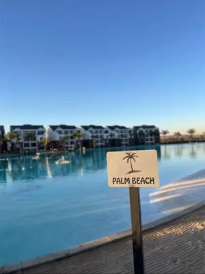 a sign in front of a swimming pool with a palm beach at The Dream Escape At The Blyde - Lagoon Facing 3 Bedroom Apartment in Pretoria