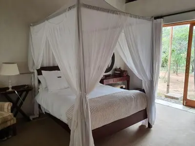 a bedroom with a canopy bed with white curtains at Mokaikai - Pride Retreat - Pax 10 in Bobbejaanstert