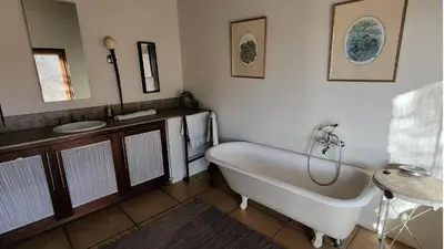 a bathroom with a tub and a sink and a mirror at Mokaikai - Pride Retreat - Pax 10 in Bobbejaanstert