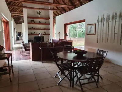 a kitchen and dining room with a table and chairs at Mokaikai - Pride Retreat - Pax 10 in Bobbejaanstert