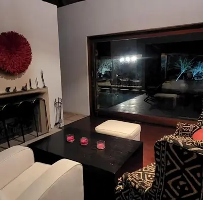 a living room with a couch and a table and a fireplace at Mokaikai - Pride Retreat - Pax 10 in Bobbejaanstert