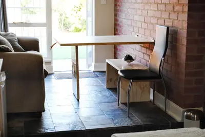 a table and chair in a living room with a couch at B and B Sandton in Johannesburg