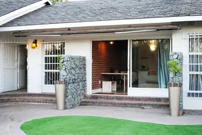a front porch of a white house with a patio at B and B Sandton in Johannesburg