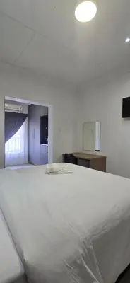 a large white bed in a white room at Good night guest house in Polokwane