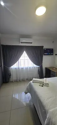 a bedroom with a large bed and a window at Good night guest house in Polokwane
