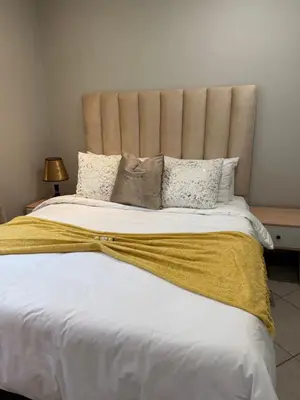a bedroom with a large bed with a large headboard at Awesome family home in Midrand