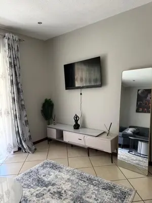 a living room with a tv on the wall at Awesome family home in Midrand